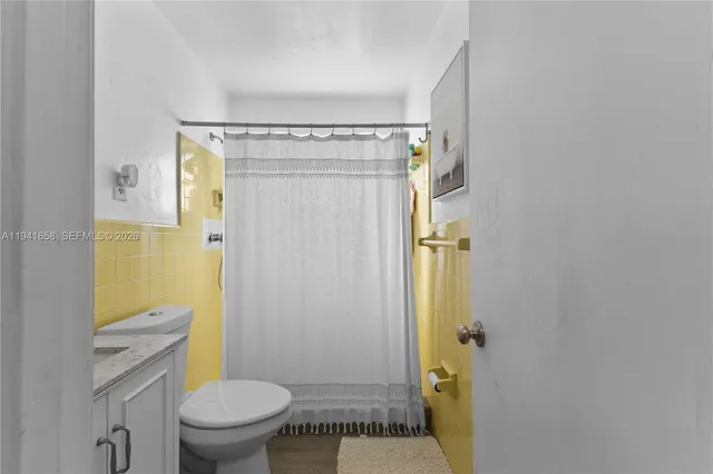 a bathroom with a granite countertop toilet and a shower