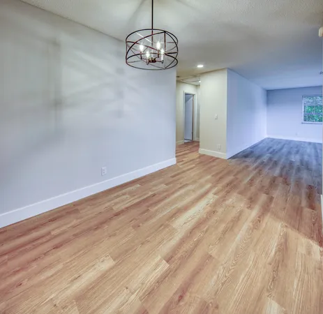 a view of empty room with wooden floor and ceiling fan