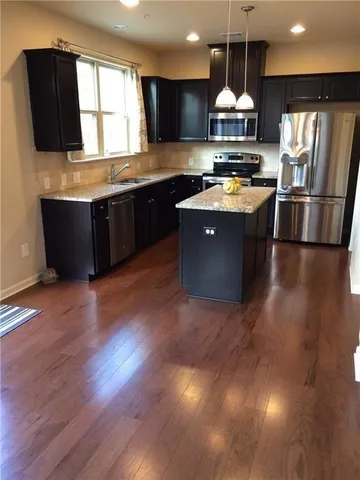 a kitchen with stainless steel appliances granite countertop a sink a stove and a refrigerator