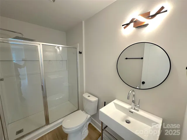 a bathroom with a sink a toilet and a mirror