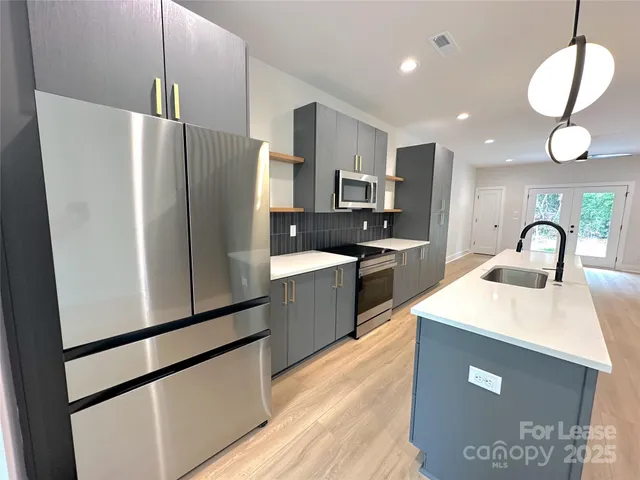 a kitchen with stainless steel appliances a refrigerator sink and microwave