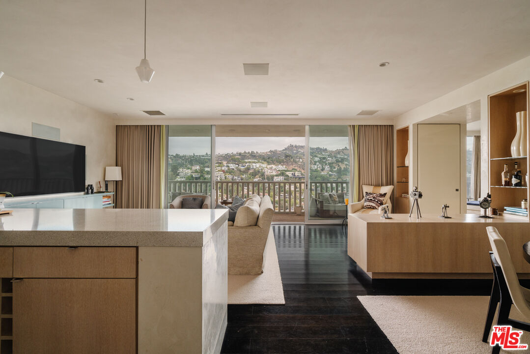 a living room with furniture a flat screen tv and a large window