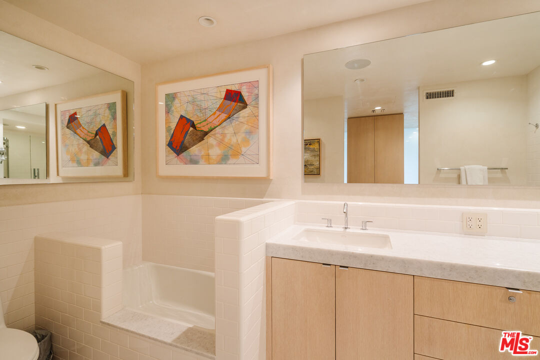 9255 Doheny Road, Unit 2603 West Hollywood, CA 90069 - Photo 11 of 17 a bathroom with a sink a mirror and a shower