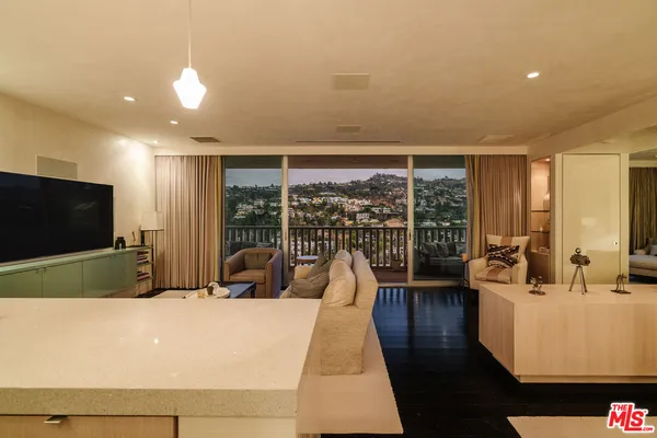 a living room with furniture a flat screen tv and a large window