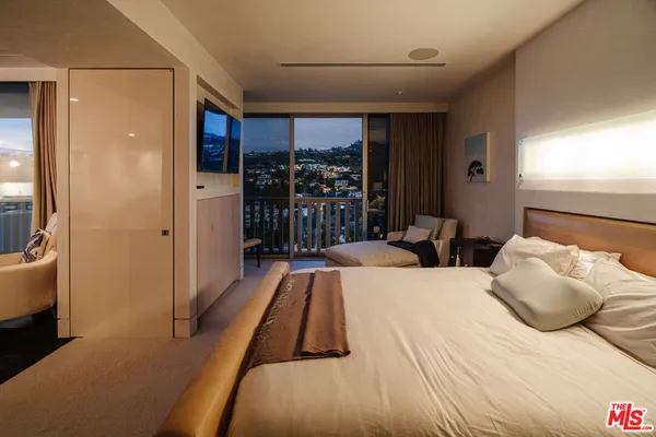 a large bedroom with a bed and a large window