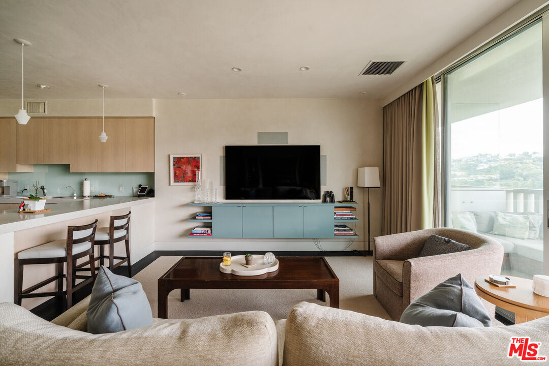 9255 Doheny Road, Unit 2603 West Hollywood, CA 90069 - Photo 5 of 17 a living room with furniture and a flat screen tv