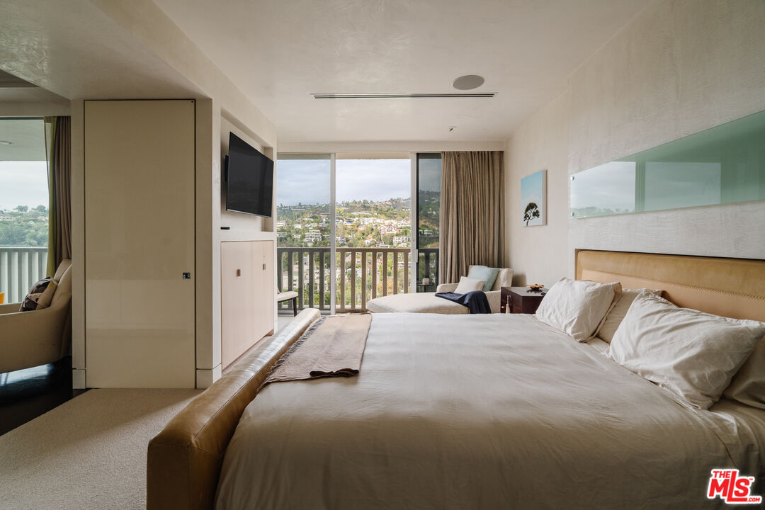 9255 Doheny Road, Unit 2603 West Hollywood, CA 90069 - Photo 10 of 17 a bedroom with a bed and glass door