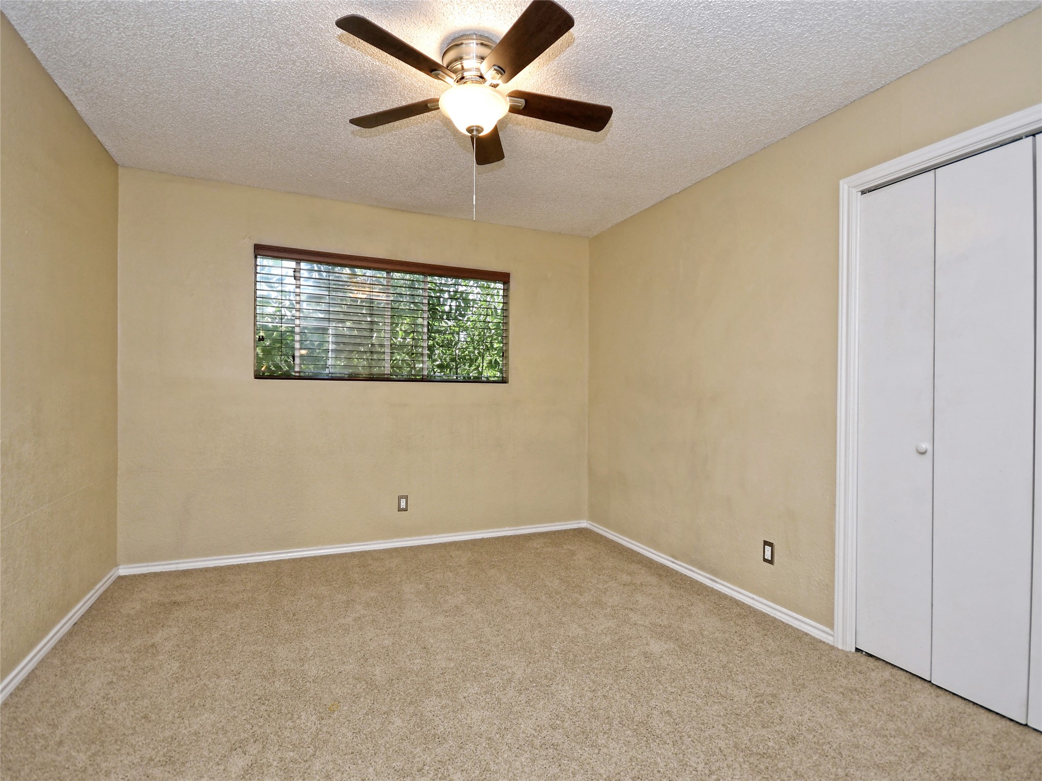 415 Fantail Loop, Unit A Austin, TX 78734 - Photo 11 of 15 Carpeted room featuring a ceiling fan with integrated lighting, a window with horizontal blinds, and a bi-fold closet