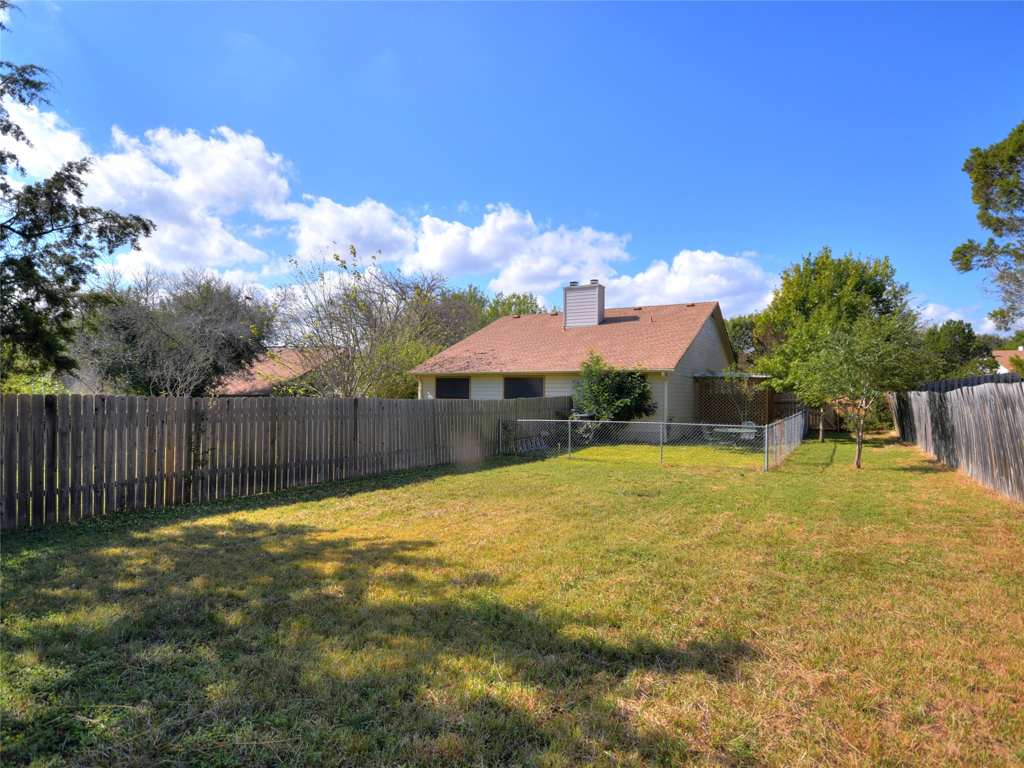 415 Fantail Loop, Unit A Austin, TX 78734 - Photo 15 of 15 Spacious backyard featuring a wood fence perimeter and a chain-link fence section
