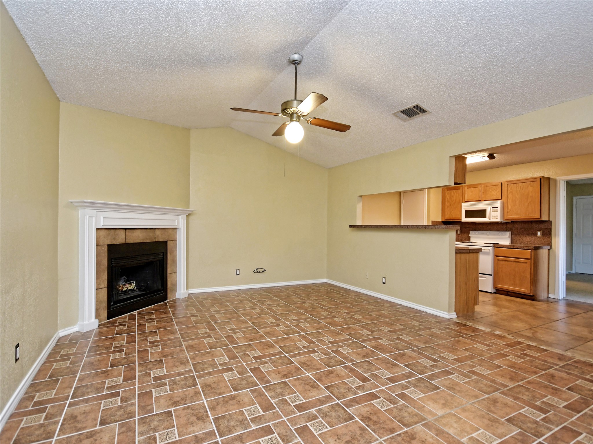 415 Fantail Loop, Unit A Austin, TX 78734 - Photo 4 of 15 Living space with a vaulted ceiling, ceiling fan, and decorative fireplace with mantel