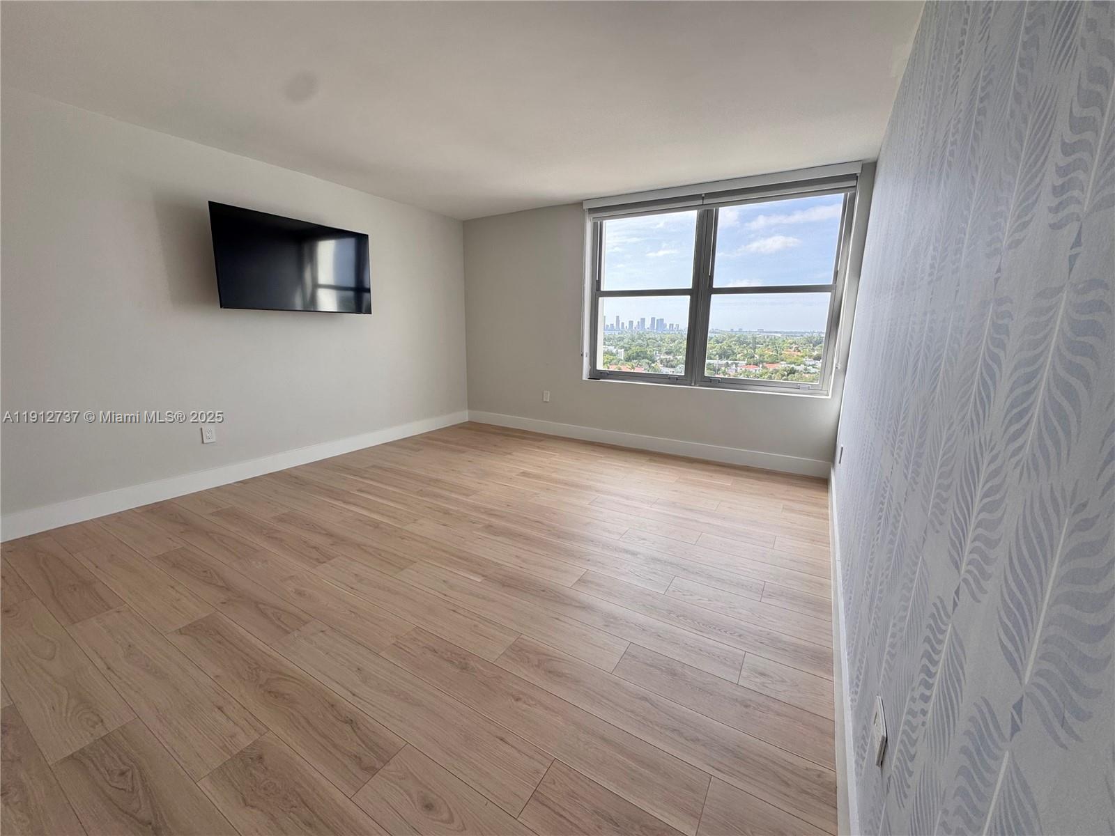2899 Collins Avenue, Unit 1212 Miami Beach, FL 33140 - Photo 11 of 37 wooden floor in an empty room with a window