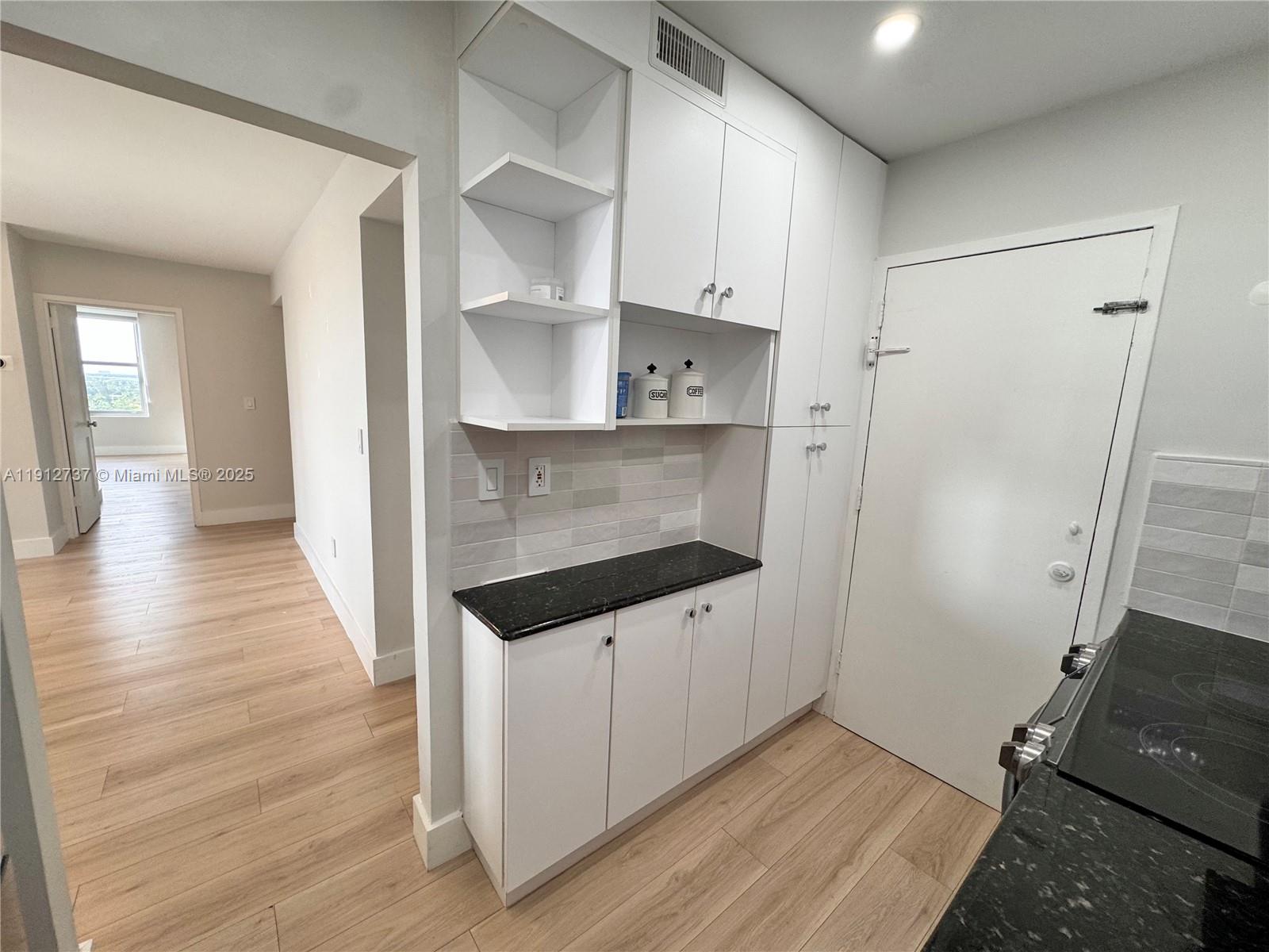 2899 Collins Avenue, Unit 1212 Miami Beach, FL 33140 - Photo 9 of 37 a kitchen with granite countertop a sink and a stove top oven