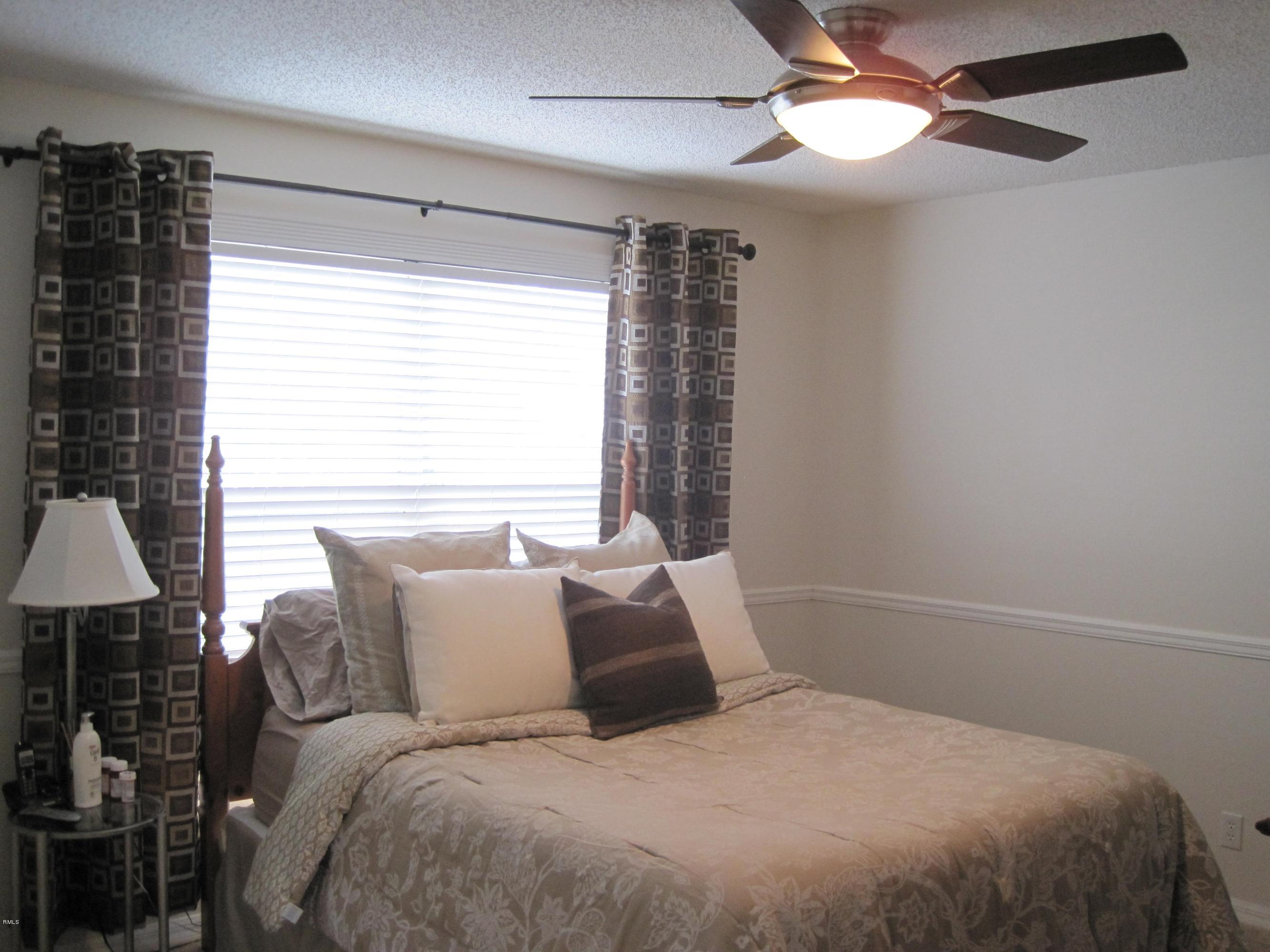 3930 Sabal Lakes Road Delray Beach, FL 33445 - Photo 12 of 30 a bedroom with a large bed and a chandelier