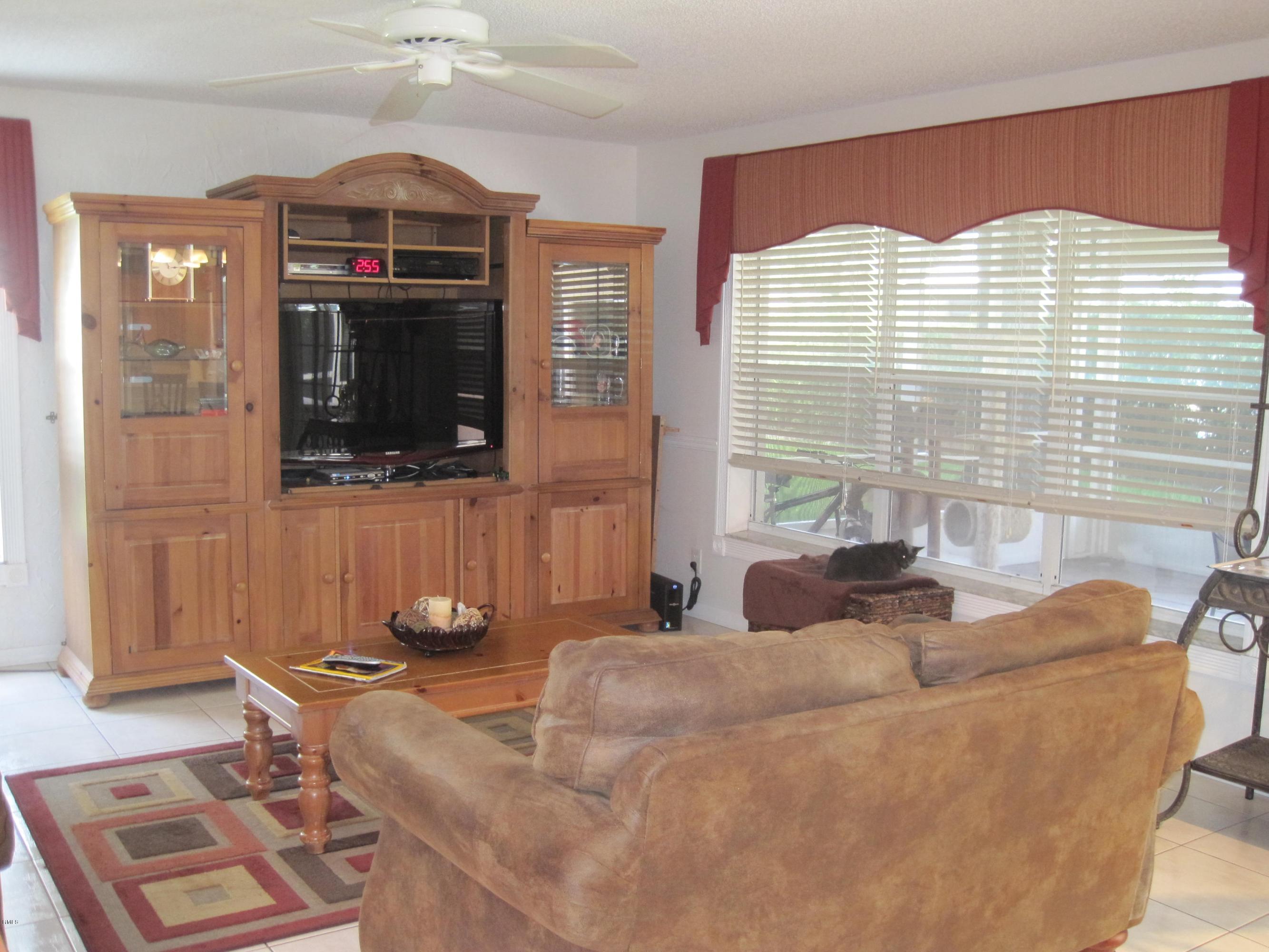 3930 Sabal Lakes Road Delray Beach, FL 33445 - Photo 2 of 30 a living room with couches a flat screen tv and outdoor view