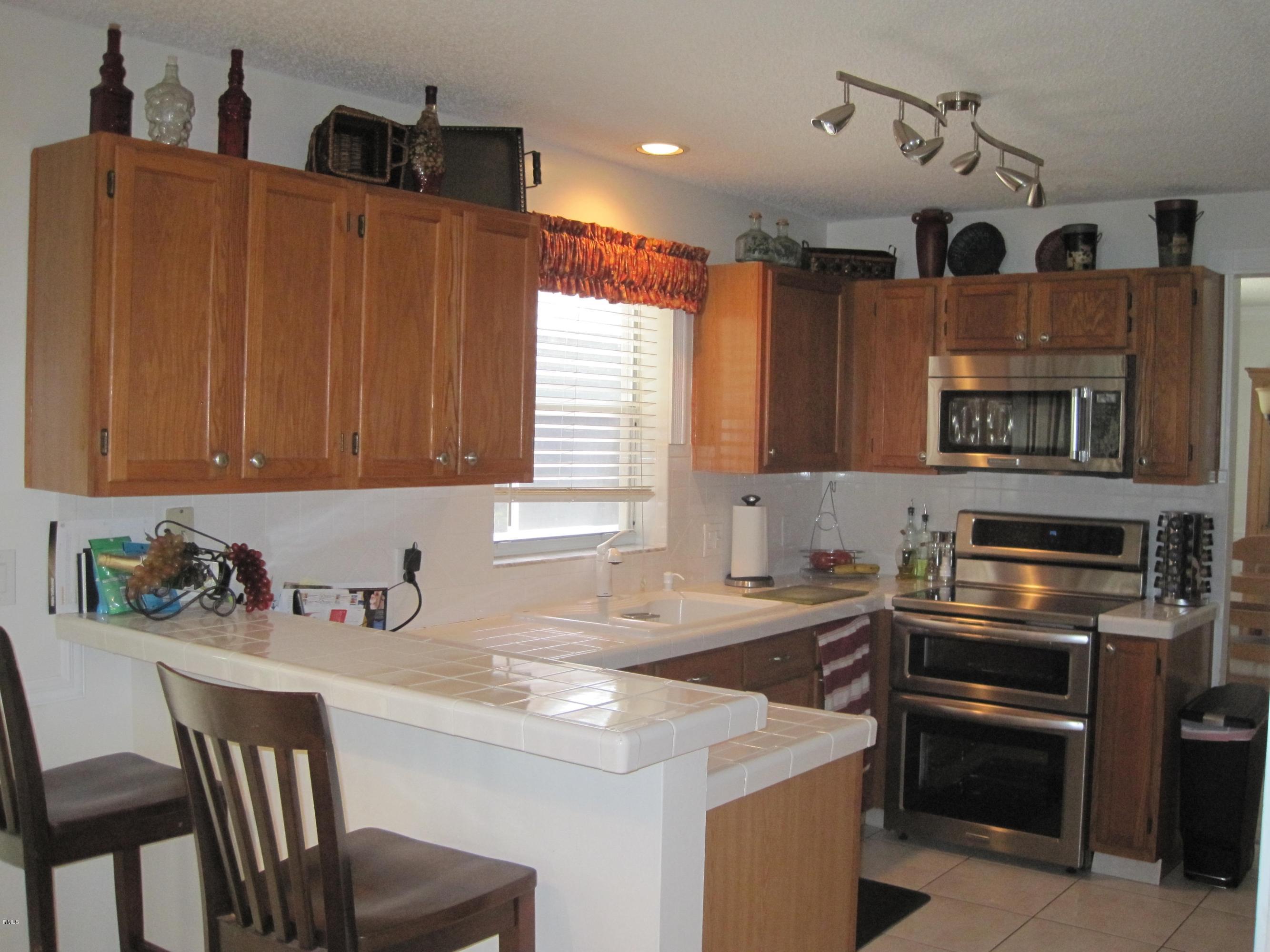 3930 Sabal Lakes Road Delray Beach, FL 33445 - Photo 5 of 30 a kitchen that has a sink and a stove in it