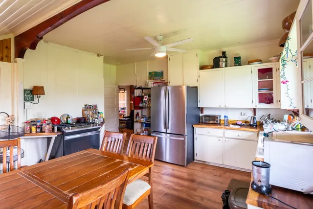 a kitchen with stainless steel appliances wooden floor and refrigerator
