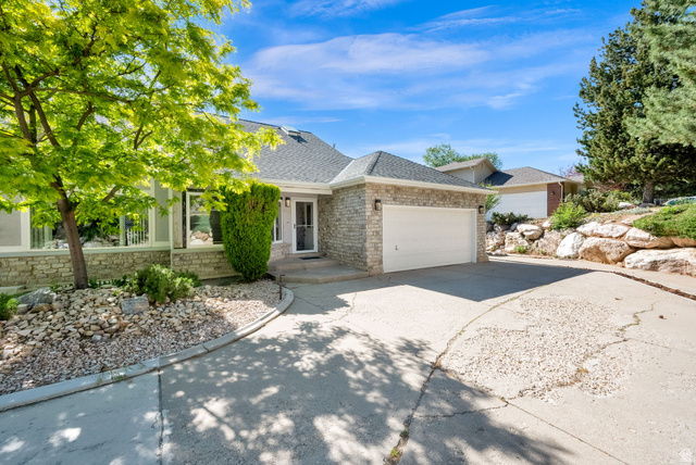 5057 South Ridgedale Drive Ogden, UT 84403 - Photo 3 of 69 Stone veneer exterior with a prominent two-car garage, multiple large windows, a welcoming front entry, and mature landscaping