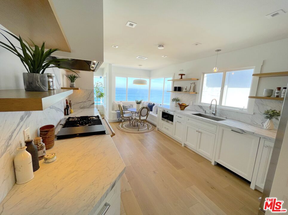 7 Camel Point Drive Laguna Beach, CA 92651 - Photo 5 of 52 a large white kitchen with sink and white cabinets