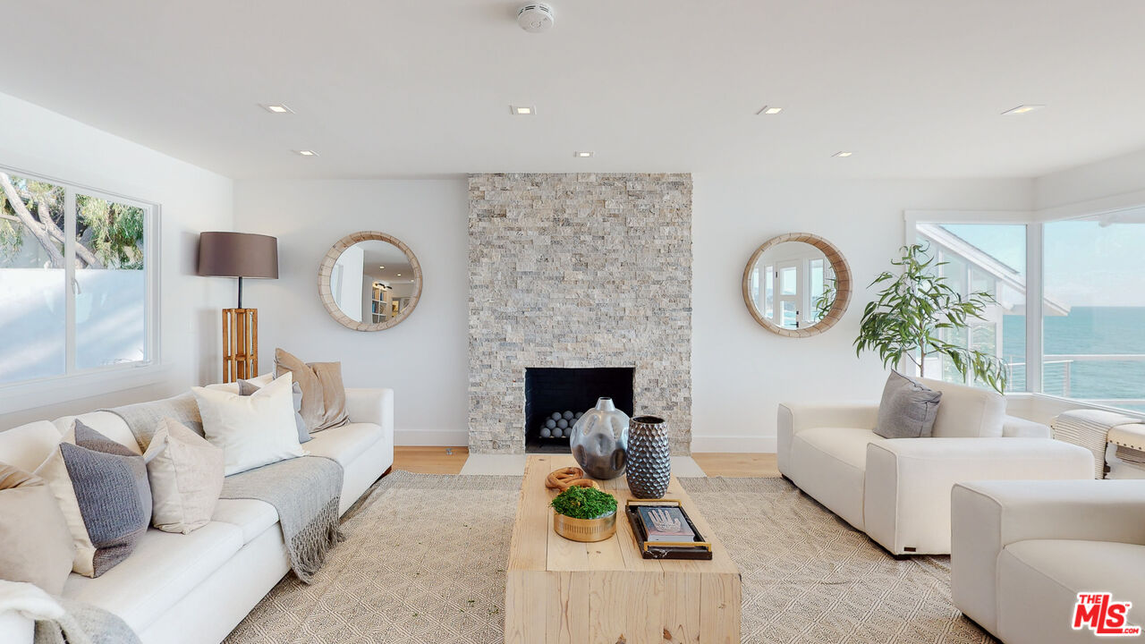7 Camel Point Drive Laguna Beach, CA 92651 - Photo 10 of 52 a living room with furniture a clock and a fireplace