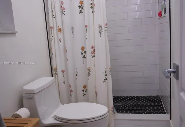 a bathroom with a toilet and a shower