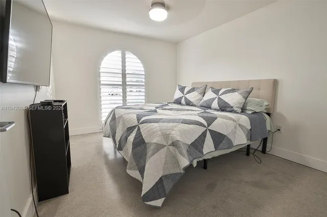 a bed sitting in a bedroom next to a window
