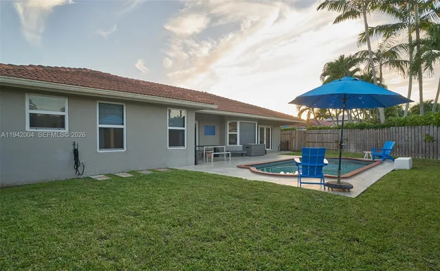 a view of a house with backyard and sitting area
