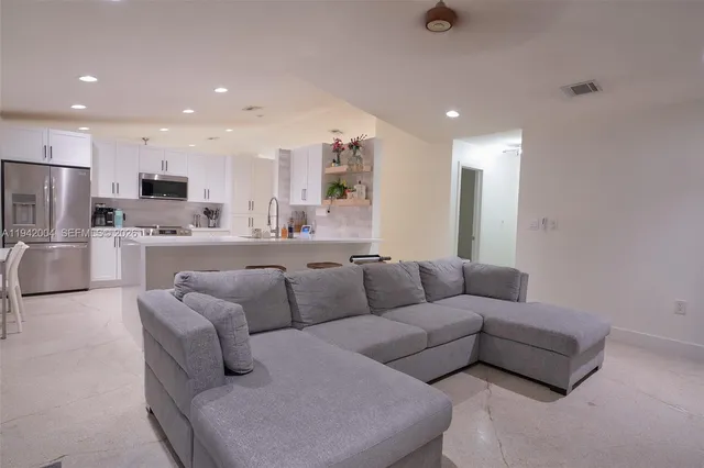 a living room with furniture and a view of kitchen