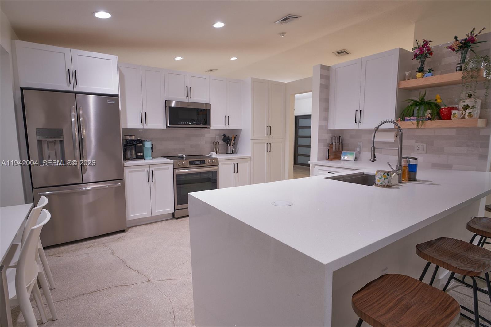 15213 Southwest 141st Street Miami, FL 33196 - Photo 6 of 18 a kitchen with kitchen island a sink stove and refrigerator