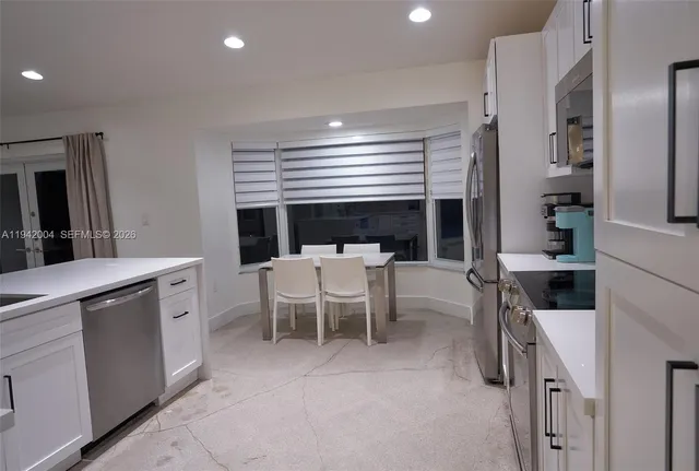 a kitchen with a sink and chairs