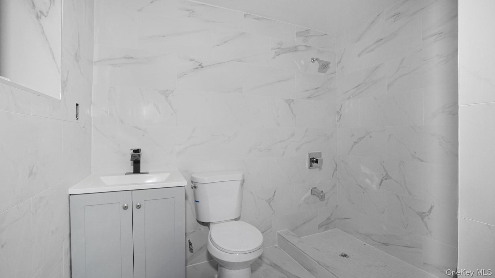 2040 Washington Avenue Bronx, NY 10457 - Photo 17 of 26 Bathroom with vanity, a shower, and tile walls