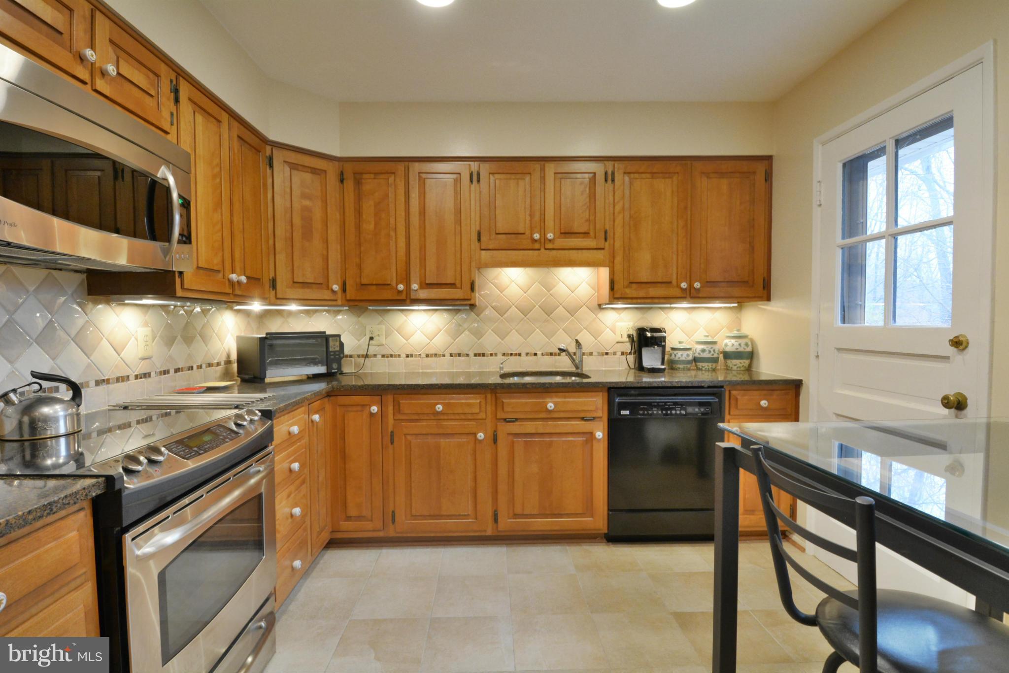7909 Slidell Lane Springfield, VA 22151 - Photo 4 of 30 a kitchen with stainless steel appliances granite countertop wooden cabinets a stove top oven a sink and dishwasher
