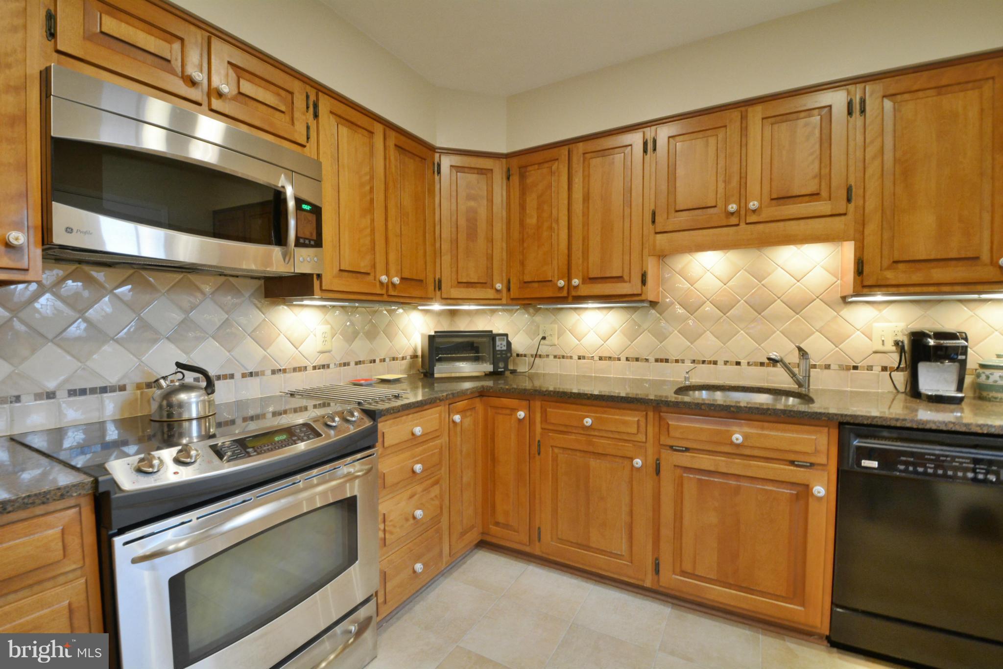7909 Slidell Lane Springfield, VA 22151 - Photo 5 of 30 a kitchen with stainless steel appliances granite countertop a sink a stove and a microwave