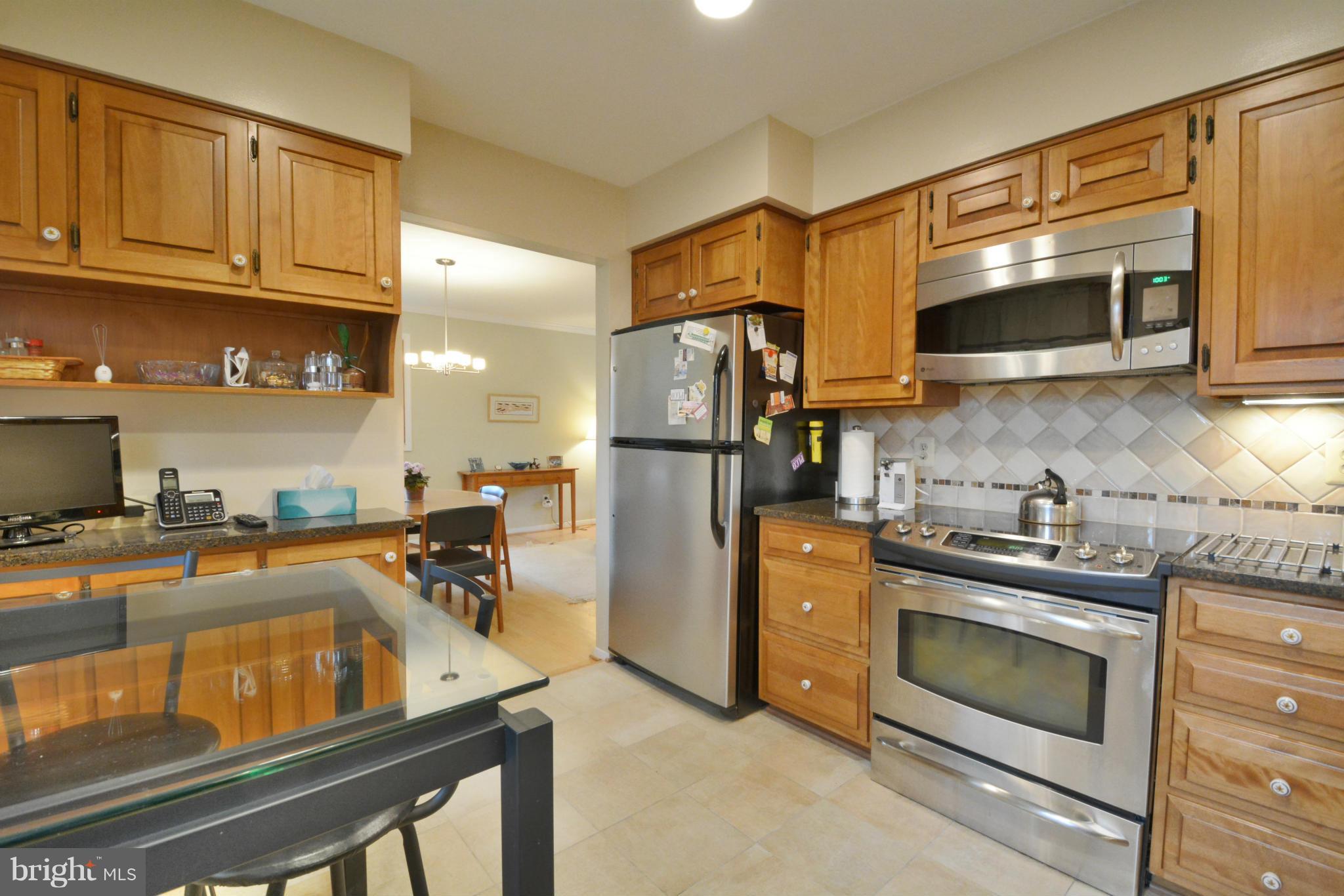 7909 Slidell Lane Springfield, VA 22151 - Photo 6 of 30 a kitchen with stainless steel appliances granite countertop a stove a refrigerator and a sink