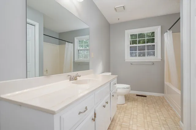 an empty room with ceiling fan and window