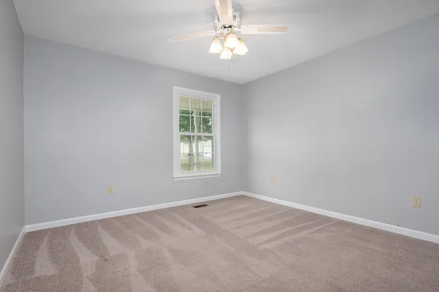 a view of an empty room with a chandelier fan