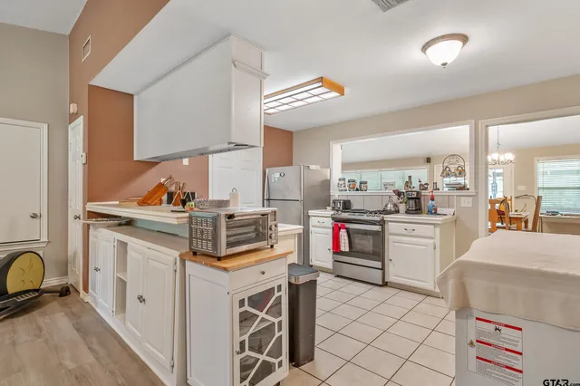 a kitchen that has a lot of cabinets in it and appliances