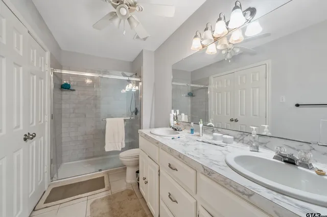 a bathroom with a double vanity sink mirror and toilet