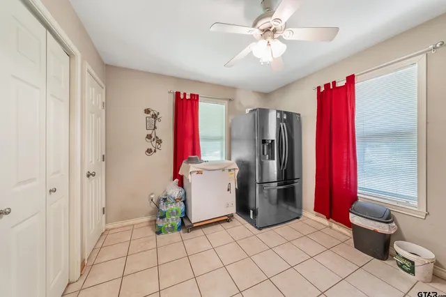 a room with a refrigerator and ceiling fan