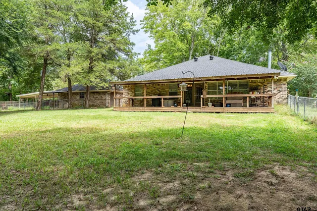 a backyard of a house with large trees and plants