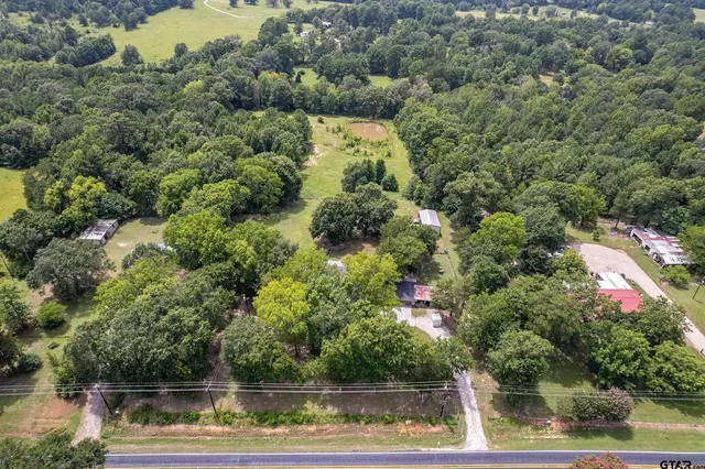 an aerial view of house with yard and swimming pool