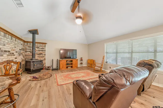 a living room with furniture a fireplace and a flat screen tv