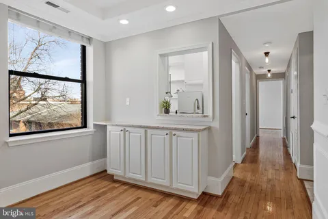 a view of a hallway with wooden floor and closet