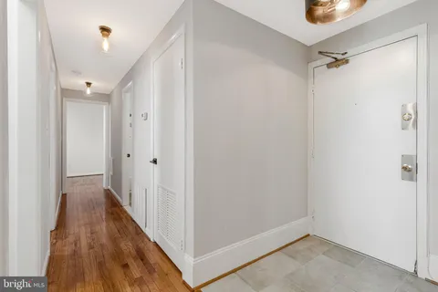 a view of a hallway with wooden floor and closet