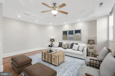 a living room with furniture and a ceiling fan