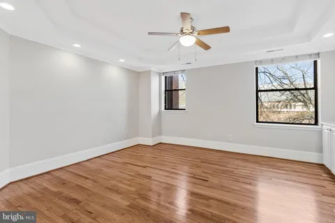 a view of a big room with wooden floor and windows