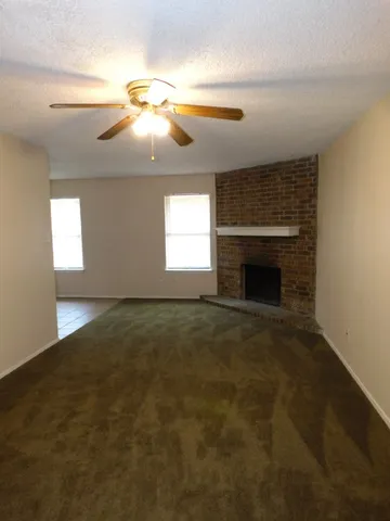 an empty room with windows and fireplace
