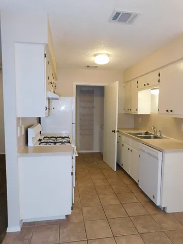 a large kitchen with a stove a sink dishwasher and a refrigerator