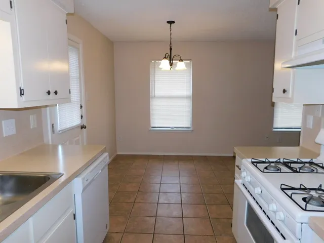 a kitchen with a sink a stove and a window