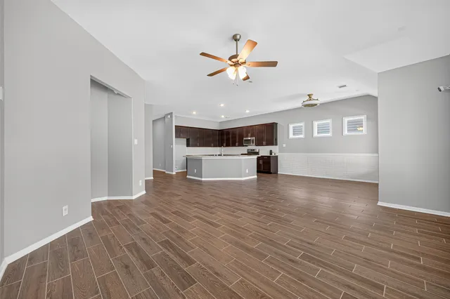 a large kitchen with stainless steel appliances granite countertop a large counter top and wooden floors