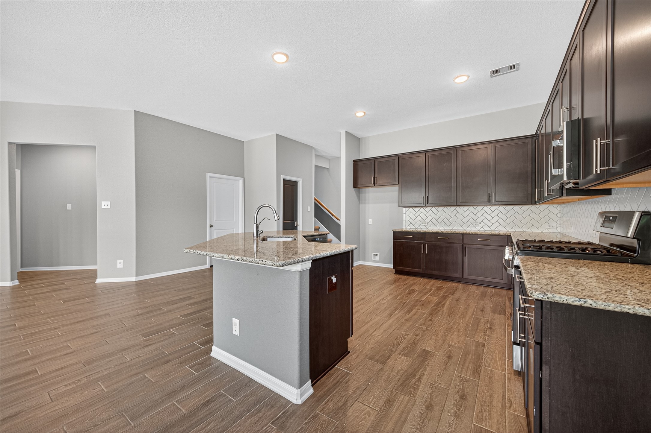 1312 Mainland Shores Lane Montgomery, TX 77316 - Photo 20 of 50 a kitchen with stainless steel appliances granite countertop a sink a stove and a wooden floors